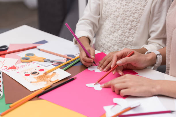 immagine ritagliata di madre e figlia afroamericana facendo cuori di carta per biglietto d'auguri - card making foto e immagini stock