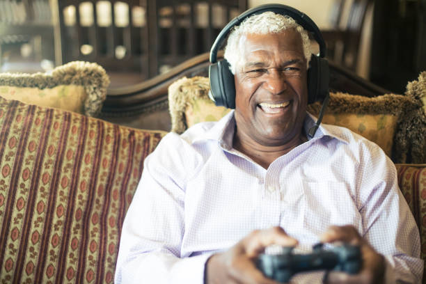 istock Senior Black Man Playing Video Games with Headphones 935695966