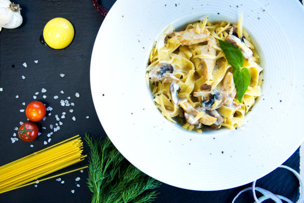 istock Pasta with mushrooms on a black slate background 935696118