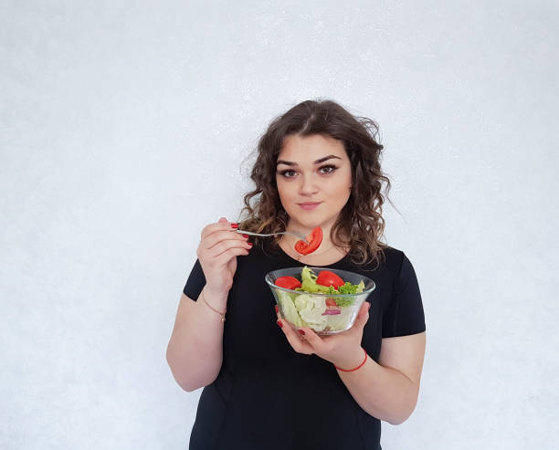 garota completa com prato de sportswear com salada - overweight women salad frustration - fotografias e filmes do acervo