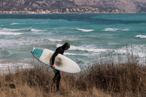 istock Surfer holding a surfboard and walking toward the sea 935701906