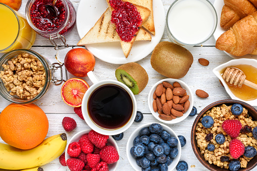 Breakfast served with coffee, orange juice, toasts, croissants, cereals, milk, nuts and fruits. Balanced diet. healthy food. top view