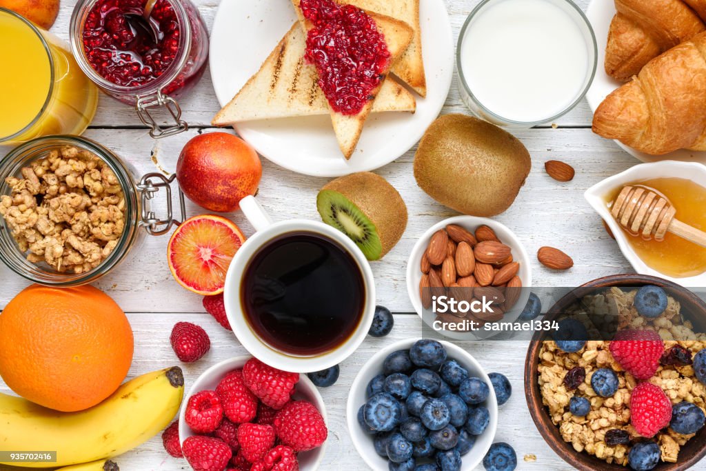 Breakfast served with coffee, orange juice, toasts, croissants, cereals, milk, nuts and fruits. Balanced diet Breakfast served with coffee, orange juice, toasts, croissants, cereals, milk, nuts and fruits. Balanced diet. healthy food. top view Breakfast Stock Photo
