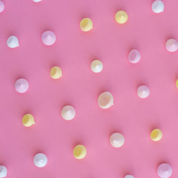 istock Multicolored meringue arranged in an even row on a pink background 935704982