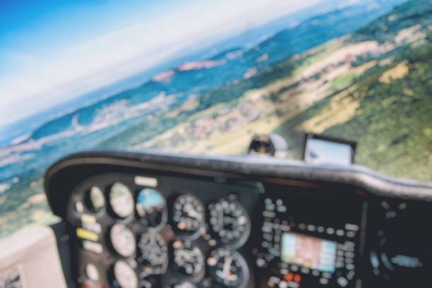 istock Defocused small airplane cockpit interior with control instrument panel and hilly landscape background in summer 935705050
