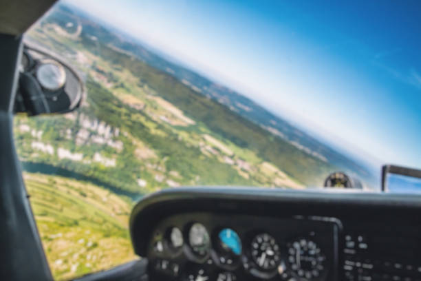 istock Defocused small airplane cockpit interior with control instrument panel and hilly landscape background in summer 935705318
