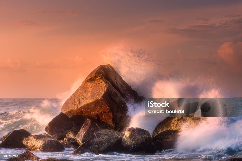 Tropical beach with rocks and big crashing waves Tropical beach with rocks and big crashing waves at sunset Mirissa, Sri Lanka Rock - Object Stock Photo