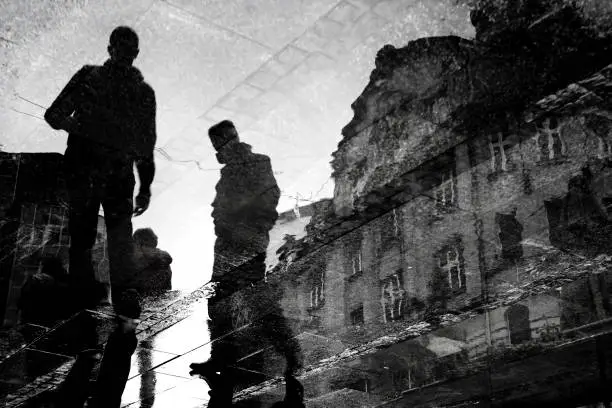 Photo of Blurry young men walking city streets reflection