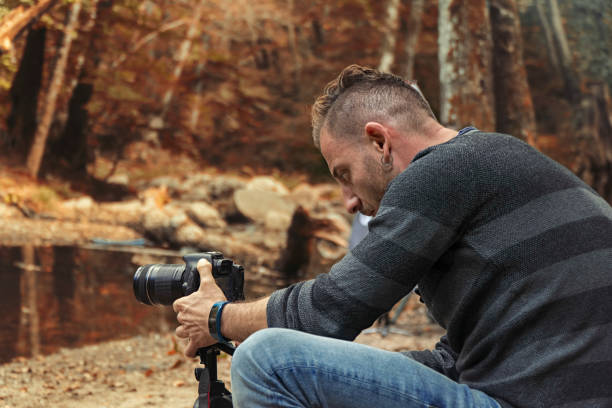 istock Man is taking photo in autumn nature forest 935711728