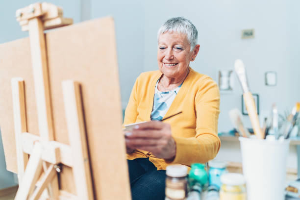 istock Senior woman painting 935715652