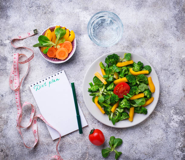 istock Healthy vegetable salad, water and measuring tape 935718254