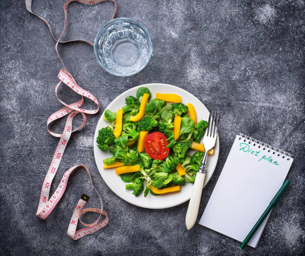 istock Healthy salad, clean water and measuring tape. 935719014