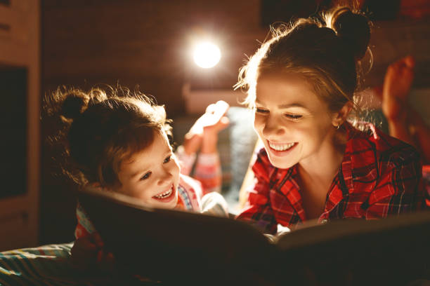 mother and child reading book in bed before going to sleep