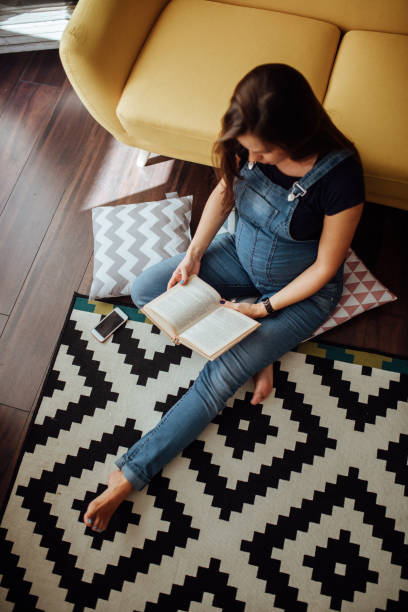 istock Future Mom relaxing with book in her apartment 935721874