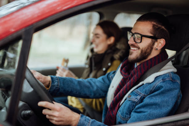 happy young couple traveling by car - travel adventure winter cold imagens e fotografias de stock