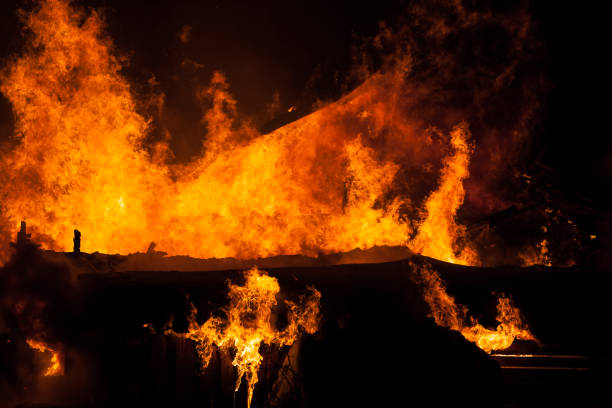 istock Burning fire flame on wooden house roof 935722588