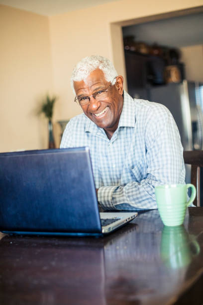 집에서 노트북 컴퓨터에서 작업 하는 수석 흑인 남자 - connection usa coffee cup mug 뉴스 사진 이미지