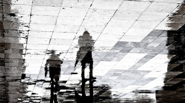 istock Blurry reflection shadow of two people on a rainy day 935725562