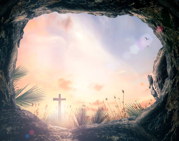 Easter Sunday concept Silhouette cross and empty tomb stone with palm leaves over meadow sunset background tomb stock pictures, royalty-free photos & images