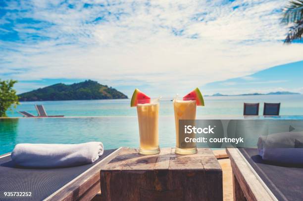 Cocktails By The Pool With Beach In The Background Stock Photo - Download Image Now