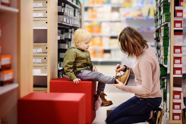 cute little boy during shopping with his young mother - shoe women adult baby imagens e fotografias de stock