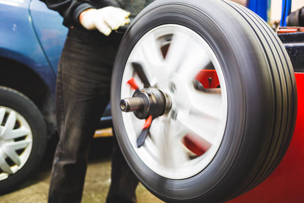 istock Mechanic aligning car tire at service 935732700