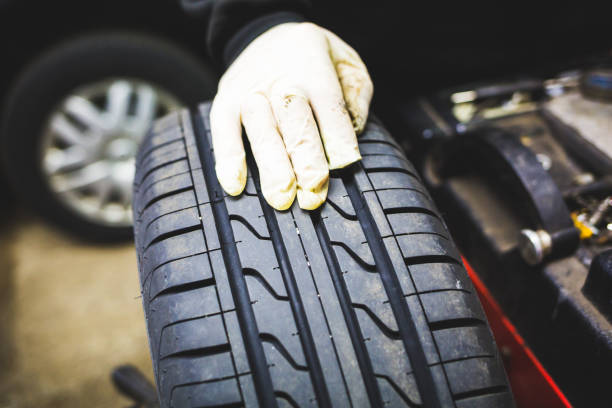 istock Mechanic aligning car tire at service 935732720
