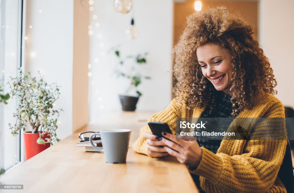 texing in cafe Beautiful young woman with a mobile phone Emoticon Stock Photo