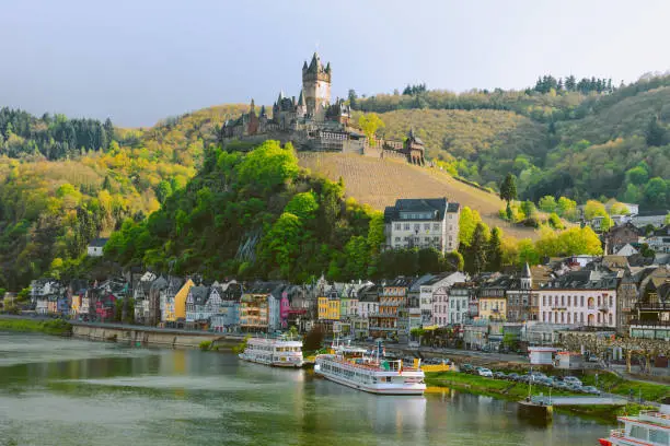 Beautiful city view of historic old town Cochem with the typical half-timbered colorful houses, hotels and restaurants, Reichsburg Imperial castle landmark on a mountain, Mittelmosel, Moselle river, Rhineland-Palatinate in sunny spring time Rheinland-Pfalz Deutschland, Europe