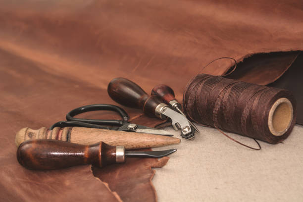 istock Tools for leather crafting and pieces of brown leather 935745904