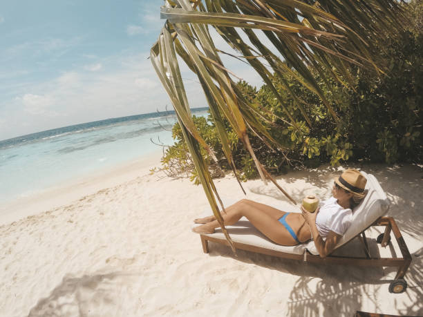 istock Young woman drinking coconut water on the beach 935751000