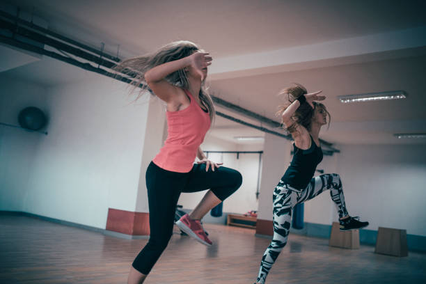 Two Females Dancing Zumba and Fitness Training in Tights in Gym Two Females Dancing Zumba and Fitness Training in Tights in Gym rumba photos stock pictures, royalty-free photos & images