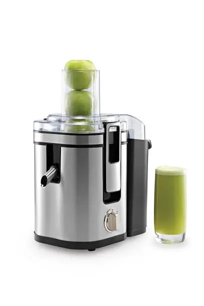 Close up juicer full of green apples