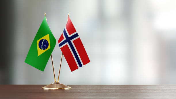 istock Brazilian And Norwegian Flag Pair On A Desk Over Defocused Background 935763236