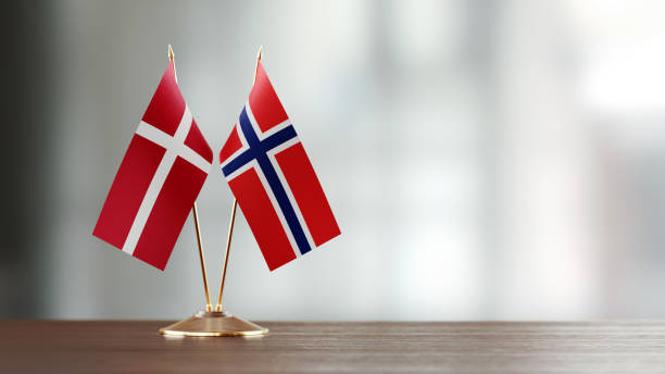 istock Danish And Norwegian Flag Pair On A Desk Over Defocused Background 935765722
