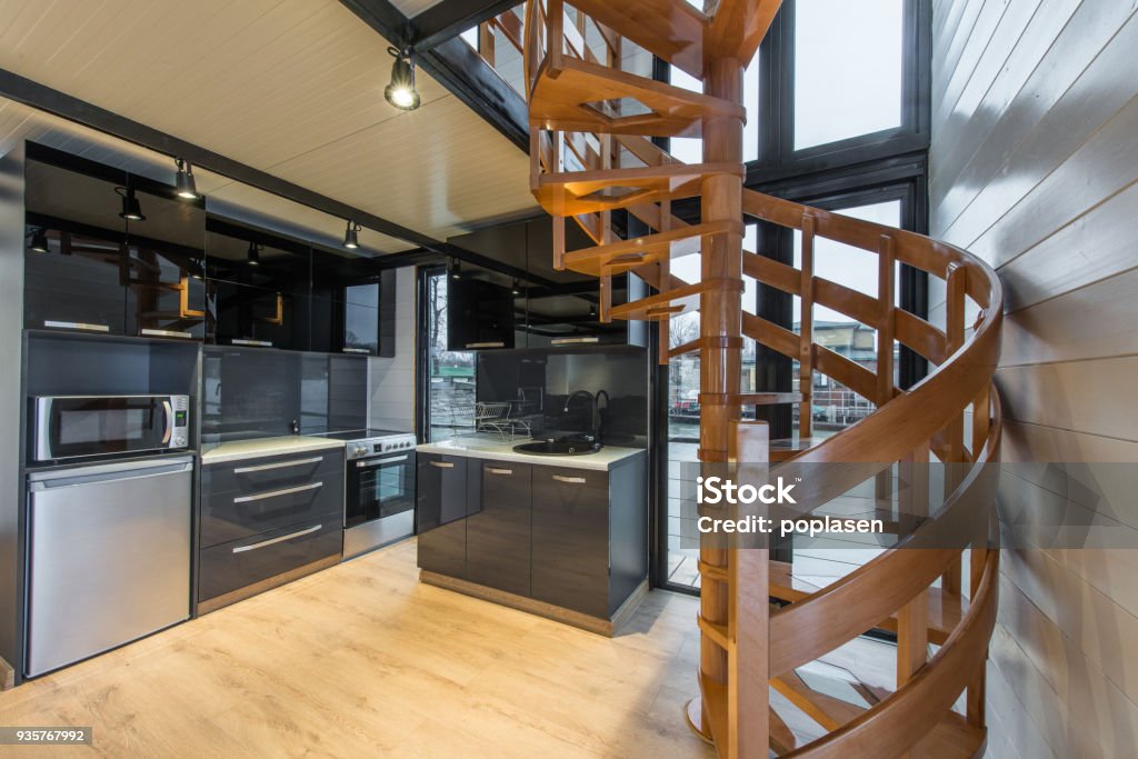 Modern kitcen interior in cottage with wooden spiral staicases Log Cabin Stock Photo