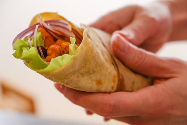 istock Mexican burrito in hand with chicken, pepper and beans 935771102