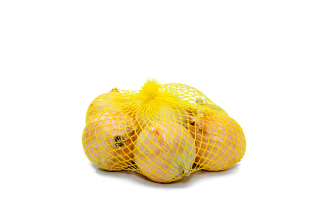 fresh onions in a yellow plastic net - onion bag netting vegetable imagens e fotografias de stock