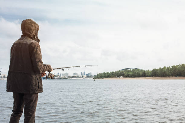 istock Young man fishing with a spinning on the river 935782234