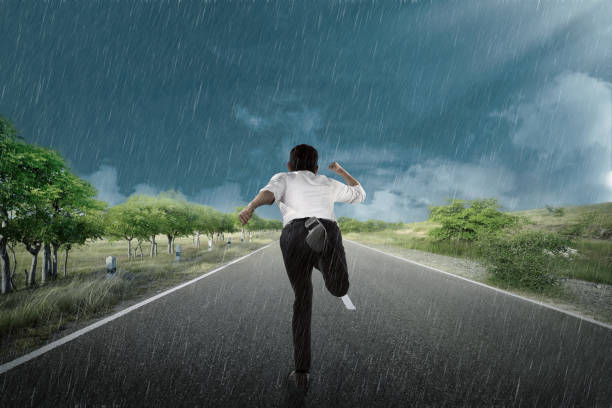 istock Businessman running under the rain 935784932