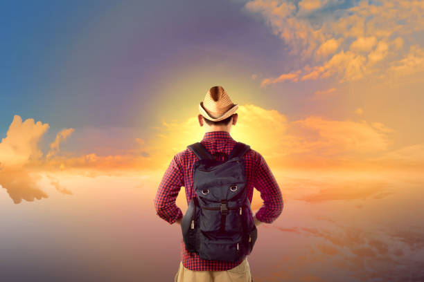 istock Rear view asian traveler looking at sunset view 935792662