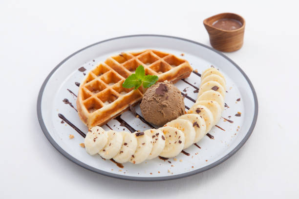 waffel mit eis und banane garniert - waffle syrup pouring breakfast stock-fotos und bilder