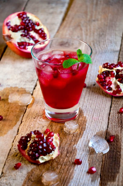 istock Pomegranate Cocktail with Ice Mint and Fruit on Wooden Table. Re 935815876