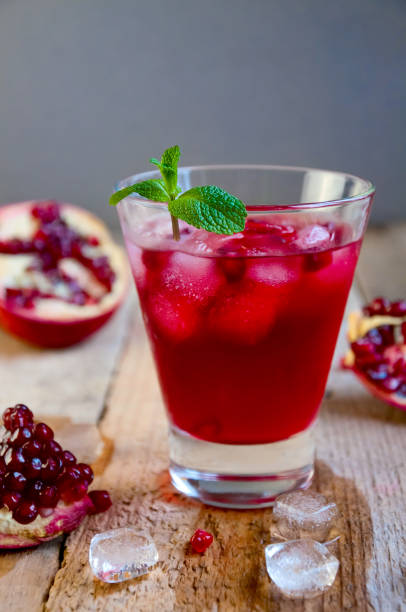 istock Pomegranate Cocktail with Ice Mint and Fruit on Wooden Table. Re 935815878