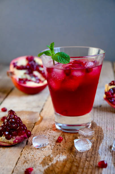 istock Pomegranate Cocktail with Ice Mint and Fruit on Wooden Table. Re 935815880