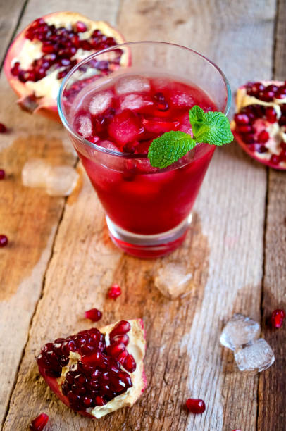 istock Pomegranate Cocktail with Ice Mint and Fruit on Wooden Table. Re 935815882