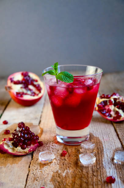 istock Pomegranate Cocktail with Ice Mint and Fruit on Wooden Table. Re 935815886