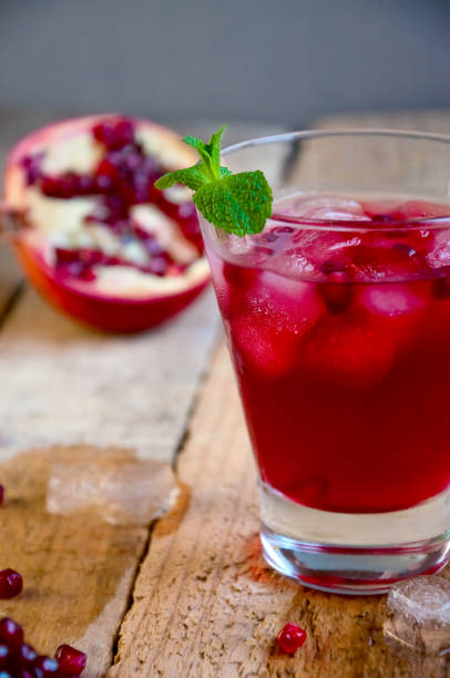 istock Pomegranate Cocktail with Ice Mint and Fruit on Wooden Table. Re 935815888