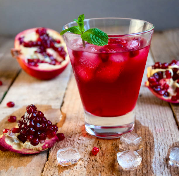 istock Pomegranate Cocktail with Ice Mint and Fruit on Wooden Table. Re 935815890
