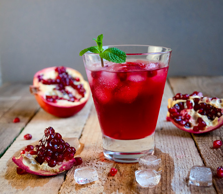 Pomegranate Cocktail with Ice Mint and Fruit on Wooden Table. Refreshing Summer Drink Soft or Alcoholic.